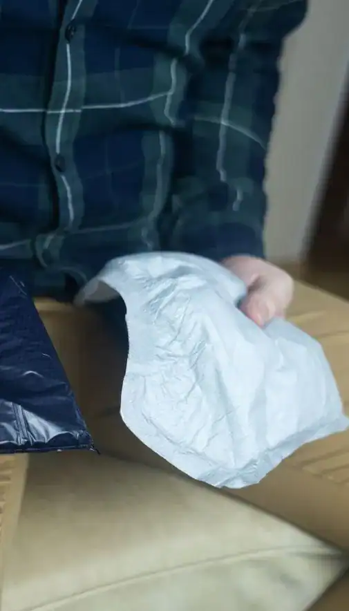 Image of man holding incontinence pads as part of overactive bladder treatment Ipswich